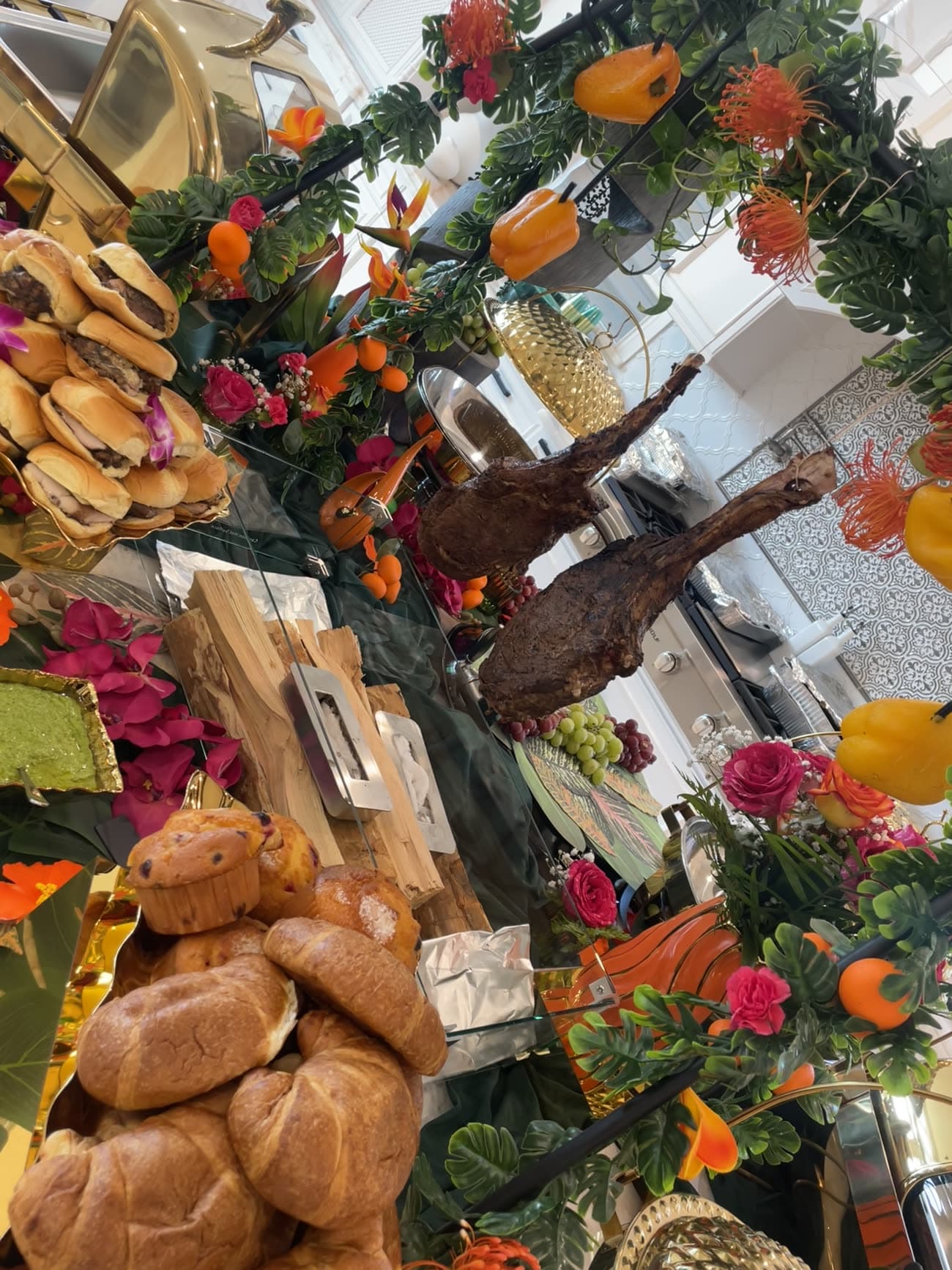 Lavish indoor buffet with a carved roast and tropical florals